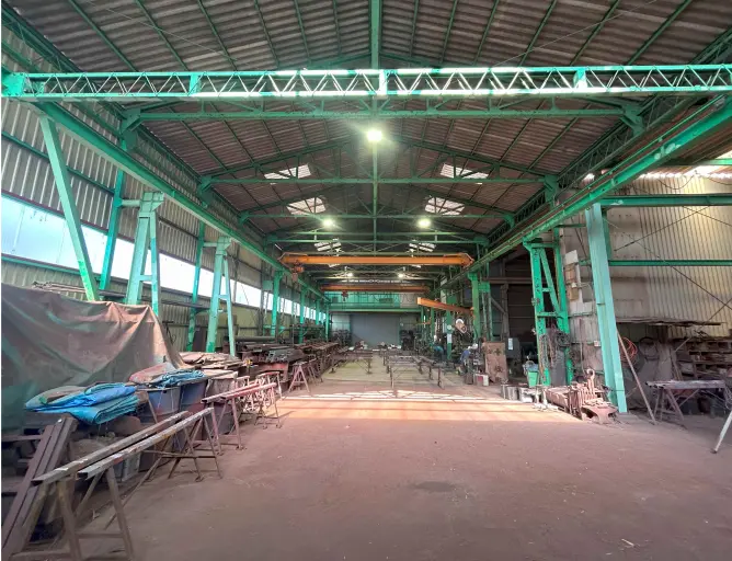 緑色の鉄骨構造が特徴的な広い工場内部