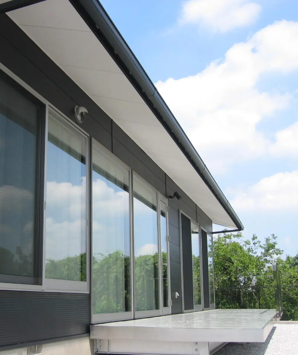 モダンな住宅の外観で、大きなガラス窓が並び、自然光を取り込む設計が特徴的